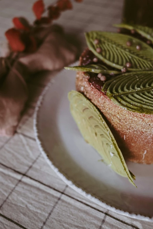 a cake sitting on top of a white plate, inspired by Charles Le Roux, unsplash, made of leaves, retro style ”, grain”, color”