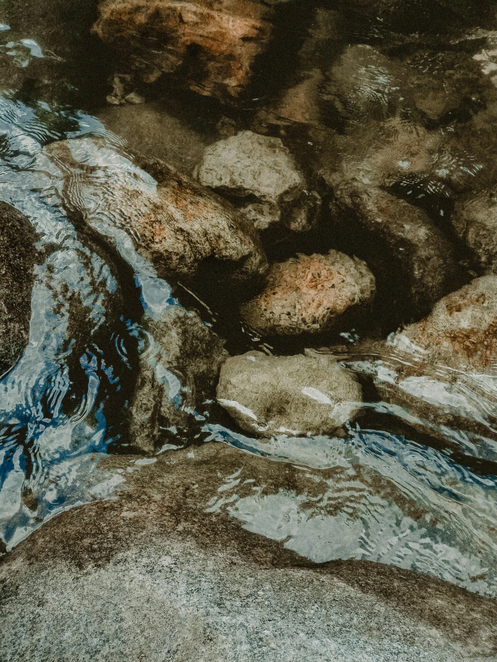 a red fire hydrant sitting on top of a river, a photorealistic painting, unsplash, tonalism, ((rocks)), underwater view, boulders, earth tones and blues