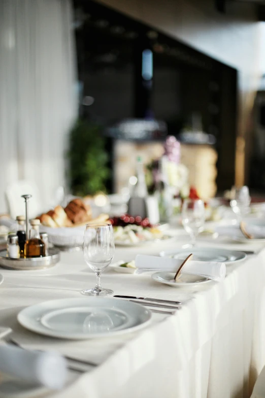 a table that has a bunch of plates on it, by Adam Marczyński, unsplash, renaissance, white tablecloth, gourmet restaurant, silver，ivory, sun light