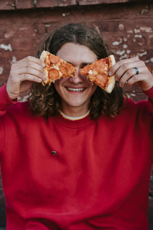 a woman holding a slice of pizza in front of her eyes, by Winona Nelson, pexels contest winner, curls on top of his head, yung lean, long hair and red shirt, smiling for the camera