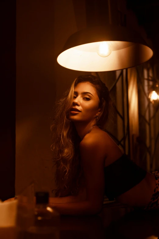 a woman wearing a halter top sits at a table