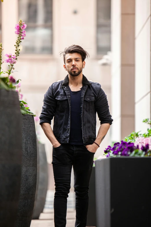 a man standing in front of a large flower pot