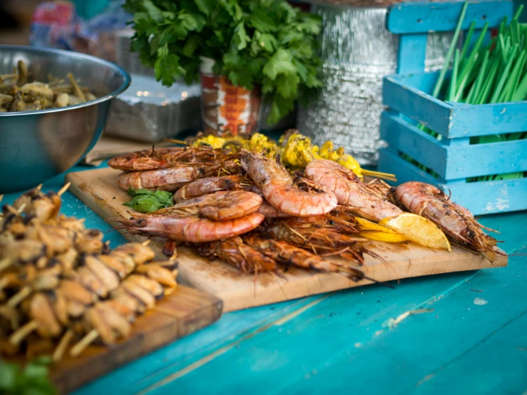 a table topped with lots of different types of food, lion fish, warm summer nights, prawn, on a wooden tray