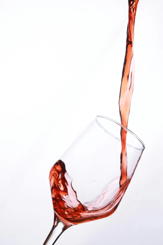 wine pouring into a glass in a white background