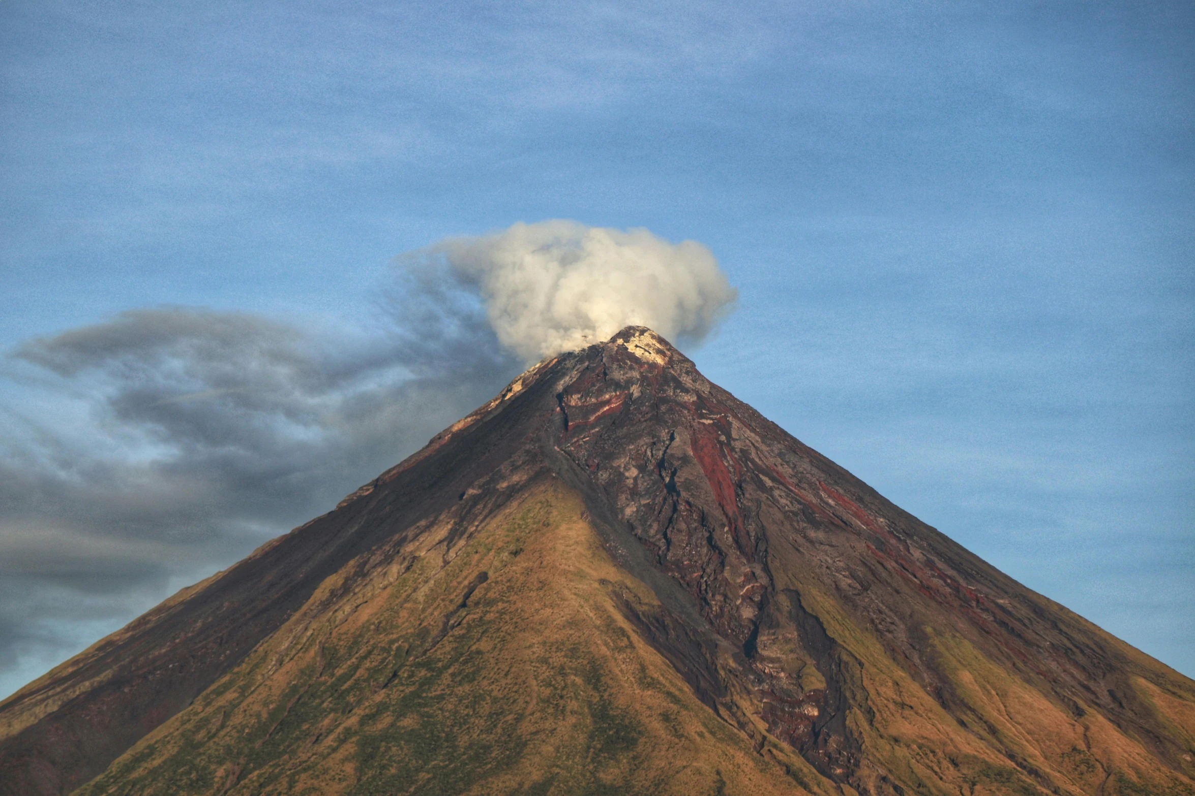 a cloud of smoke is billowing from the top of a mountain