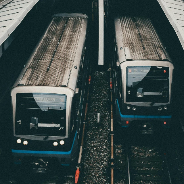 two trains parked next to each other at a train station, a picture, unsplash, modernism, instagram post, blue and gray colors, dark underground, birdseye view