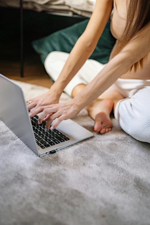 a woman sitting on the floor using a laptop, reddit, thumbnail, intimate, carpeted floor, hands reaching for her