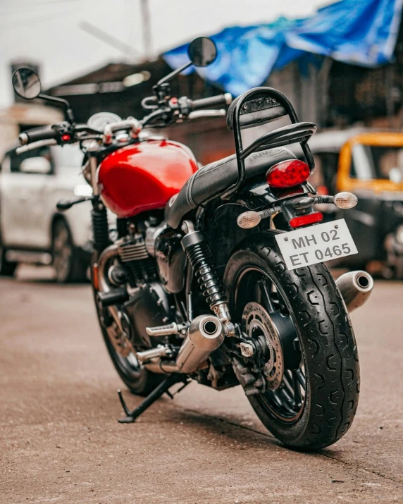 a red motorcycle parked on the side of the road, by Tom Bonson, pexels contest winner, streets of mumbai, triumph, close-up shot from behind, inspect in inventory image