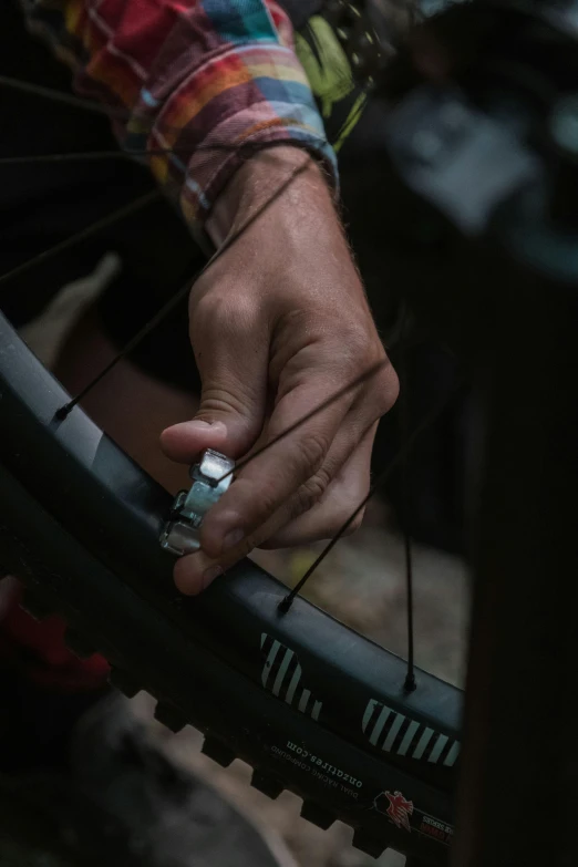 the man is repairing his bicycle tire