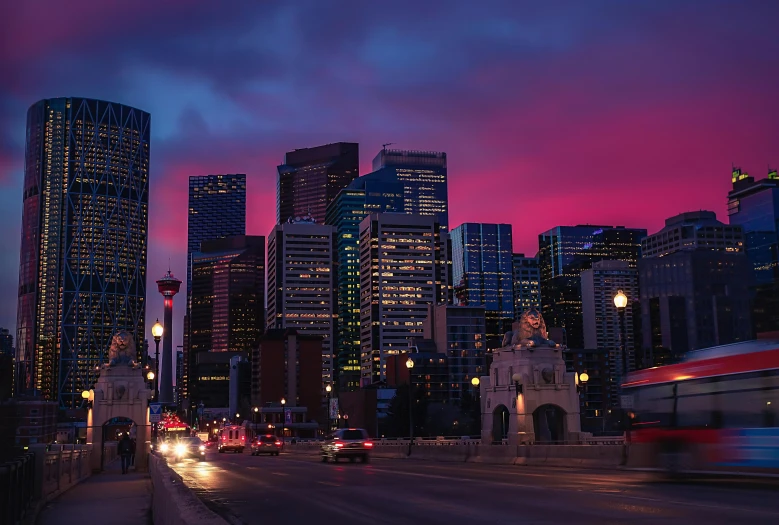 a street at night with a city in the background