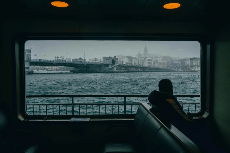 a person sitting down and looking out on the river