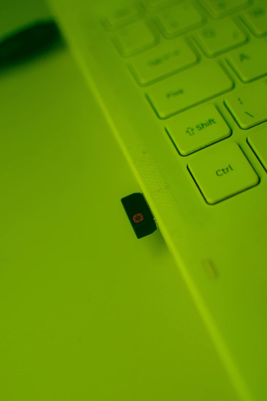 an open laptop computer sitting on top of a table, inspired by Lucio Fontana, unsplash, bright green dark orange, closeup - view, switch, micro detail