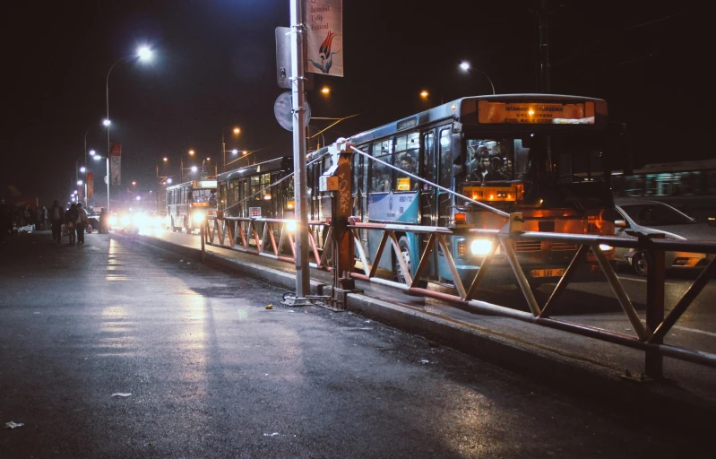 a bus on a city street at night, eytan zana, overpass, maintenance photo, people