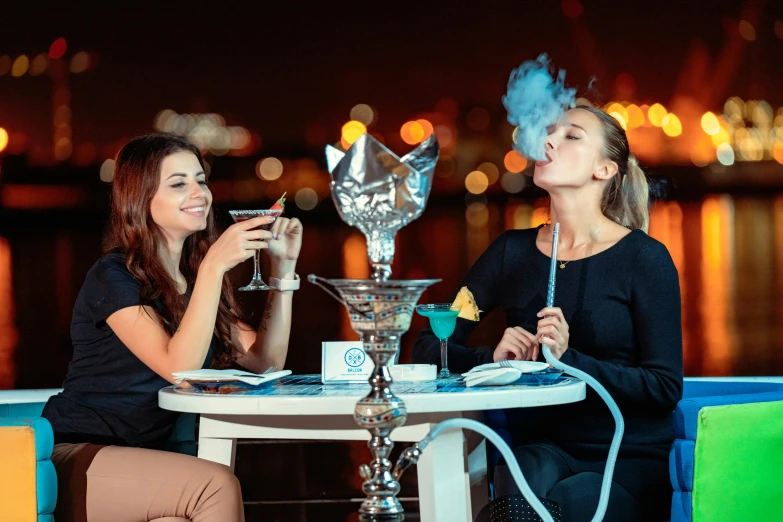 two women sitting at a table smoking a hook, pexels contest winner, hurufiyya, beautiful genie girl, people drink cocktails, thumbnail, blue