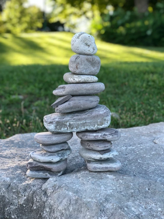 a pile of rocks sitting on top of a rock, inspired by Andy Goldsworthy, flying cloud castle, two organic looking towers, made of cement, standing on boulder