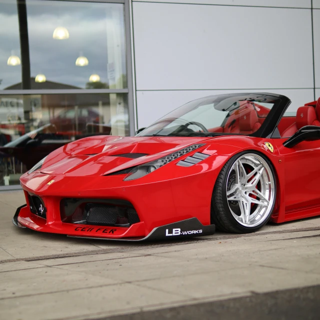 this red sports car is parked in front of a glass building