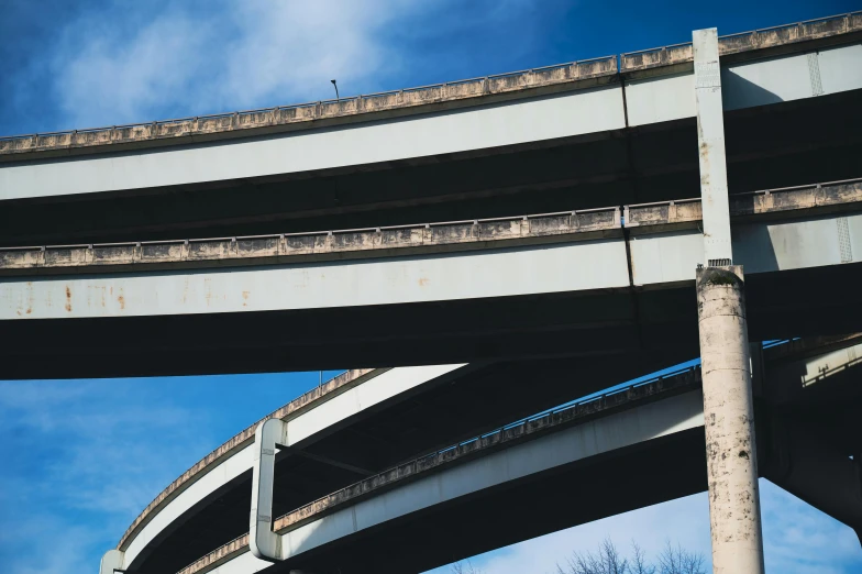 a couple of overpasss that are next to each other, by Washington Allston, unsplash, brutalism, overpass, blue sky, traffic, close - up photograph