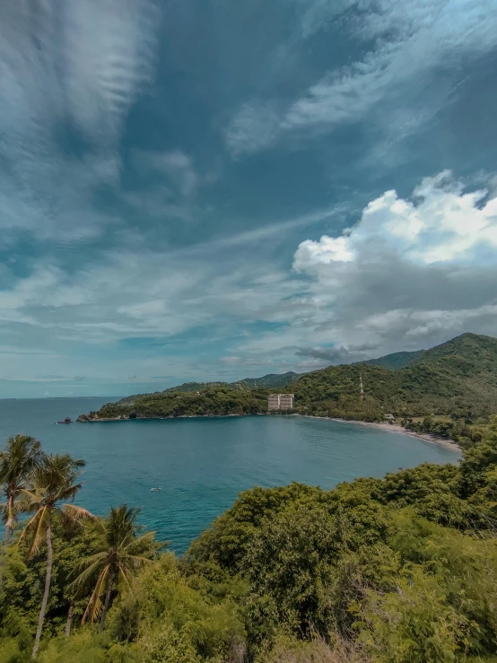 a large body of water sitting on top of a lush green hillside, beach and tropical vegetation, like jiufen, thumbnail, cinematic image