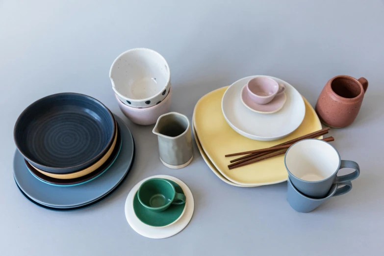 a number of plates and cups on a table, a still life, inspired by Lewis Henry Meakin, unsplash, minimalism, square, pastel deep colours, murata range, with a white background