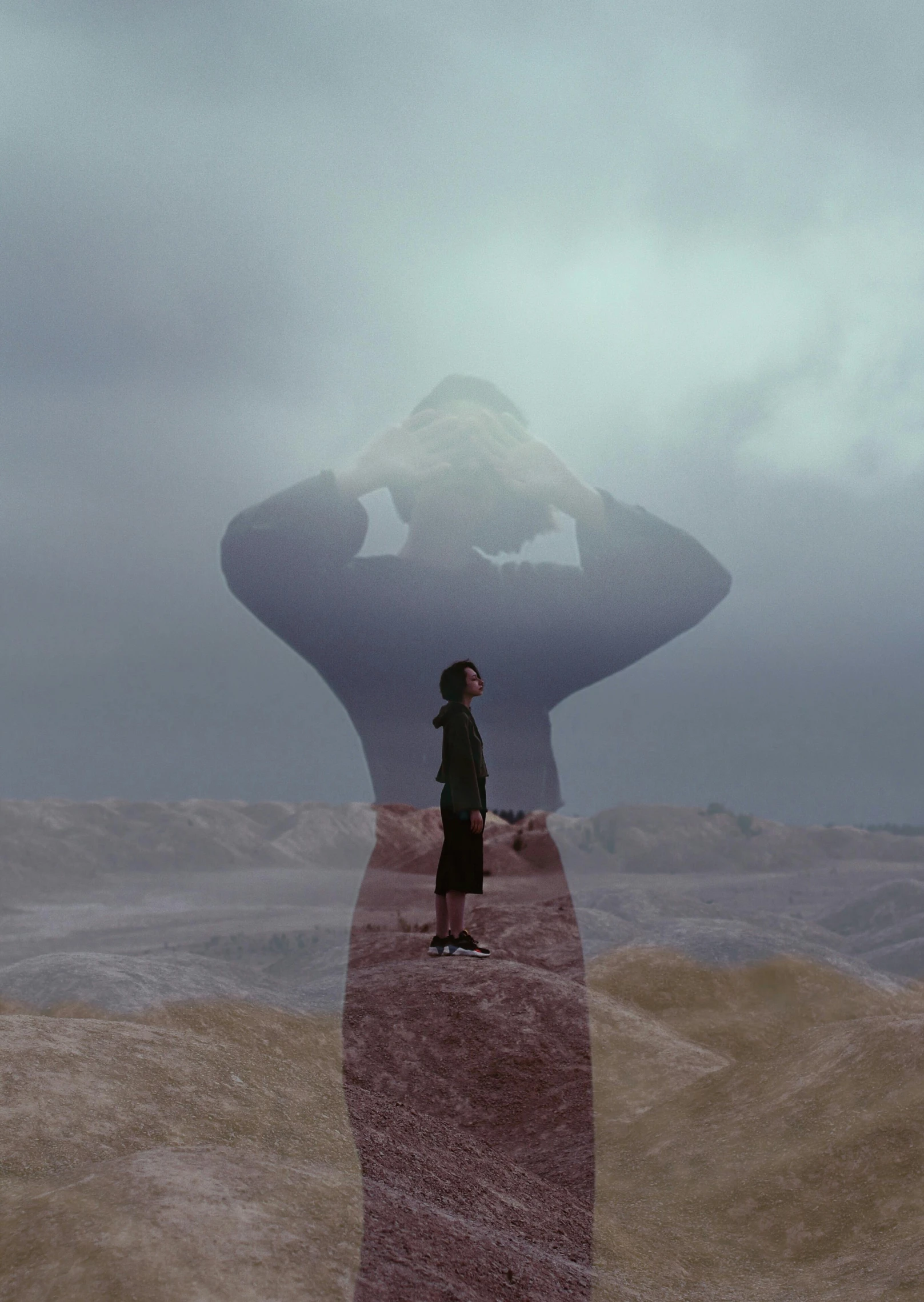 the man is standing on a small red road near the mountain