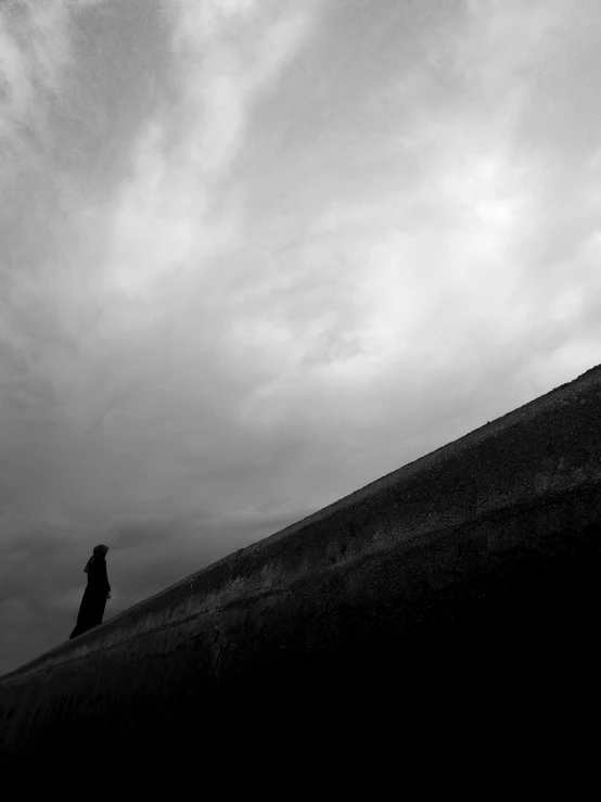 a lone person stands alone at the top of a hill