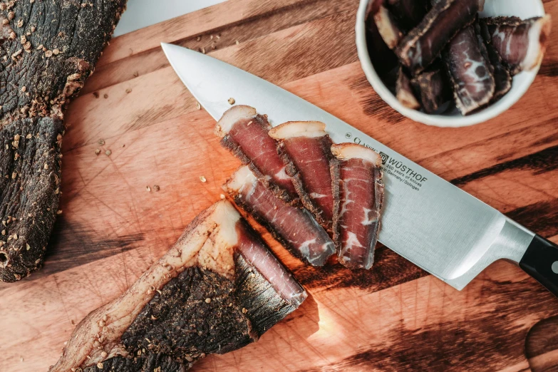 a knife sitting on top of a wooden cutting board, 🦩🪐🐞👩🏻🦳, creterion collection, ham, pikes