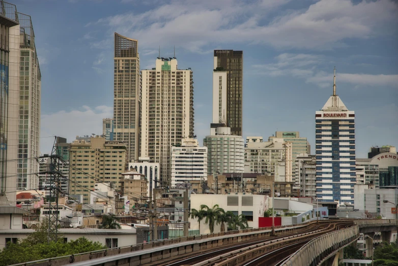 a train traveling through a city next to tall buildings, by Tom Wänerstrand, unsplash contest winner, hyperrealism, bangkok, chimneys on buildings, 2000s photo, fan favorite