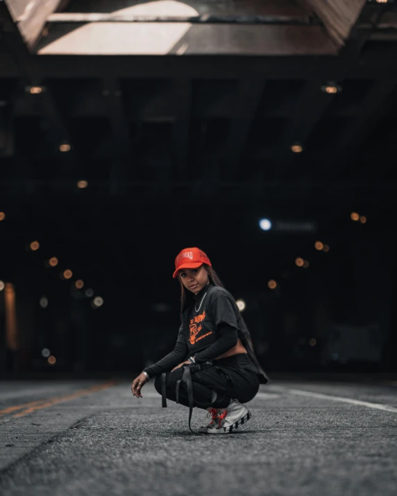 a person kneeling down in the middle of a road, unsplash contest winner, graffiti, non binary model, red cap, red and orange glow, black on black