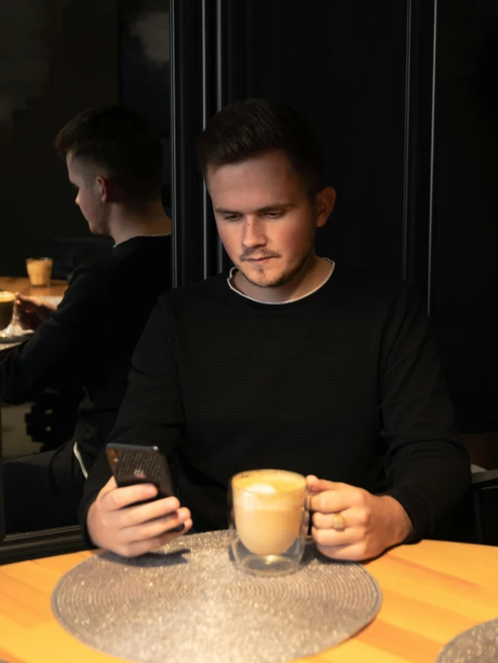 a man sitting at a table with a cup of coffee, discord profile picture, lachlan bailey, low quality photo, kacper niepokolczycki