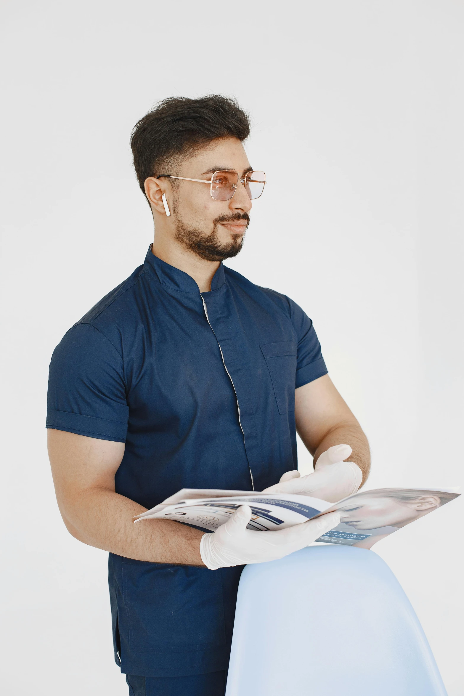 man standing with newspaper in hand over blue cloth