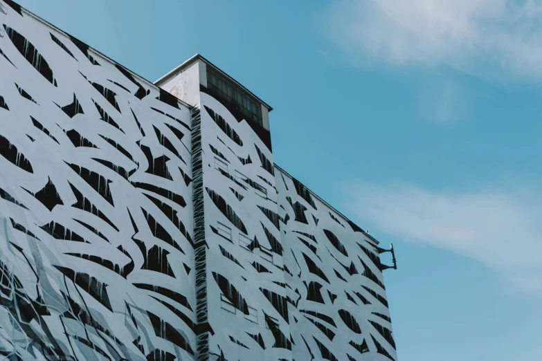 a close up of a building with a sky background, a cartoon, inspired by Zaha Hadid, unsplash contest winner, brutalism, patterned clothing, dazzle camouflage, espoo, urban jungle