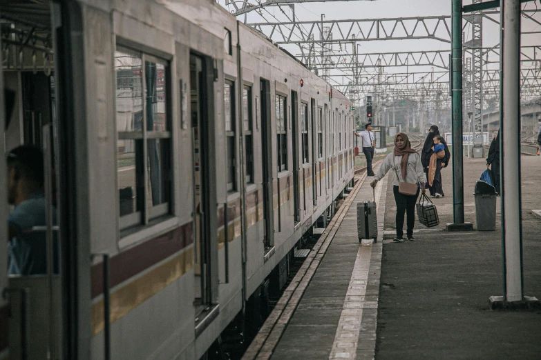 a group of people standing on a platform next to a train, pexels contest winner, south jakarta, 🚿🗝📝, thumbnail, square