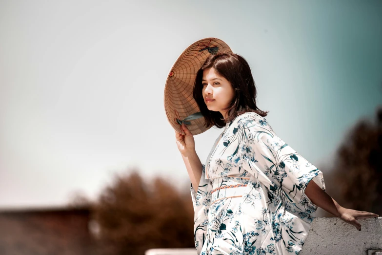 a girl with brown hair is holding her hat