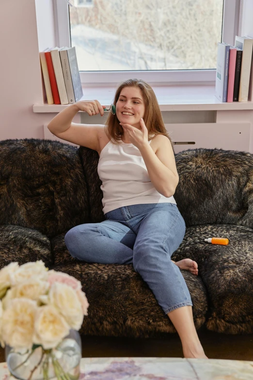 a woman sitting on a couch in a living room, by Julia Pishtar, trending on reddit, slightly overweight, sits on a finger, snacks, high quality photo
