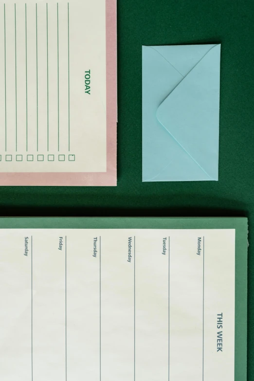 a notepad sitting on top of a green table, graphic detail, 3 - piece, muted pastels, organized