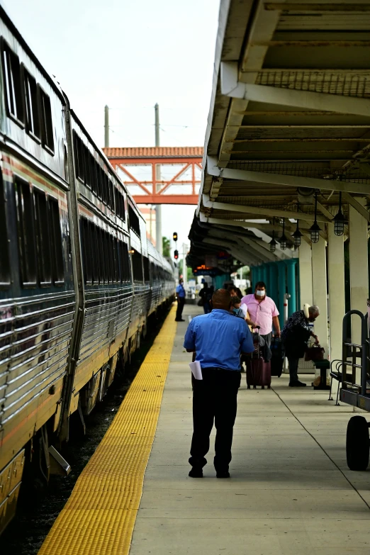 a group of people standing on a platform next to a train, bay area, train station, afternoon time, covid