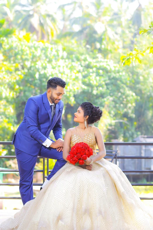 a man in a blue suit standing next to a woman in a wedding dress, by Max Dauthendey, pexels contest winner, assamese aesthetic, bouquet, at the terrace, pr shoot