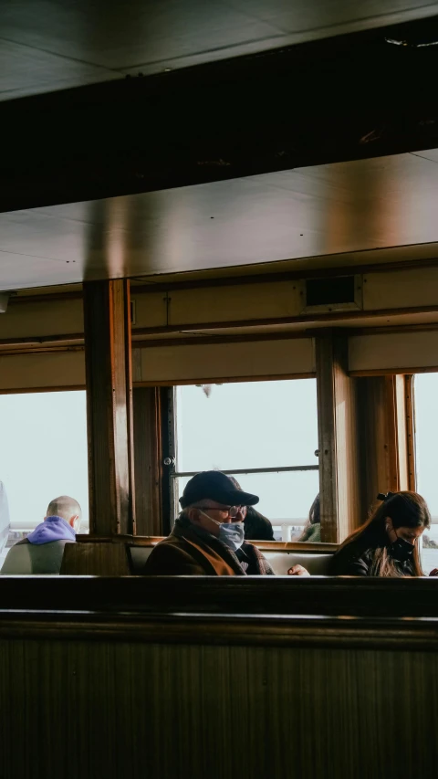 a group of people sitting on top of a train, a portrait, unsplash, ship interior, thumbnail, low quality photo, sitting in a cafe alone