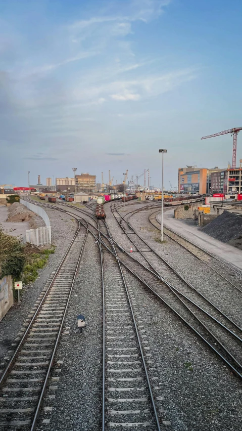 there is a train that is going down the tracks, by Dan Scott, unsplash, drone view of a city, yard, high quality photo, square