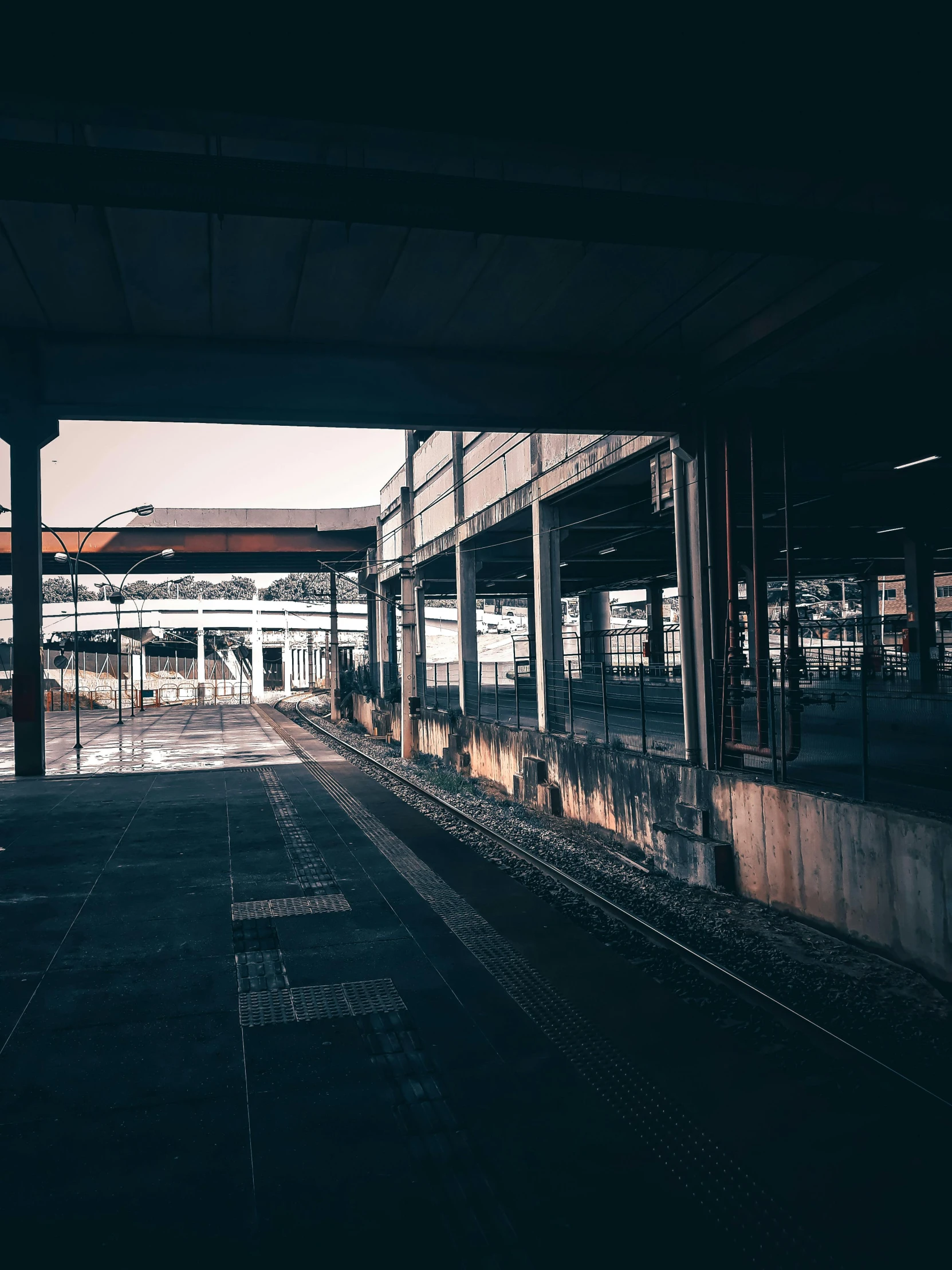 a black and white photo of a train station, inspired by Elsa Bleda, unsplash contest winner, industrial colours, an abandonded courtyard, photo on iphone, golden hour cinematic