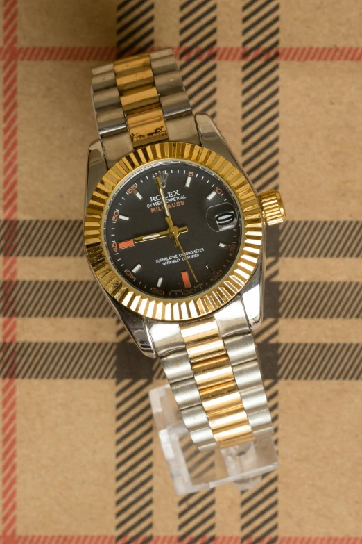 a close up of a watch on a table, a portrait, by Kev Walker, rolex, thumbnail, !female, black and gold colors