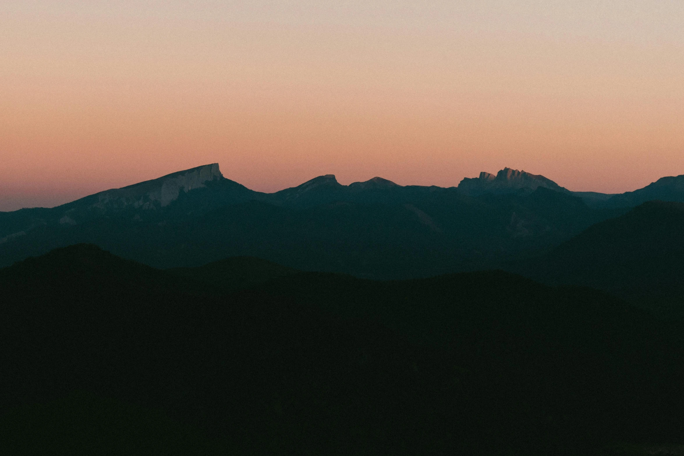 a airplane is flying over the mountains in the sky