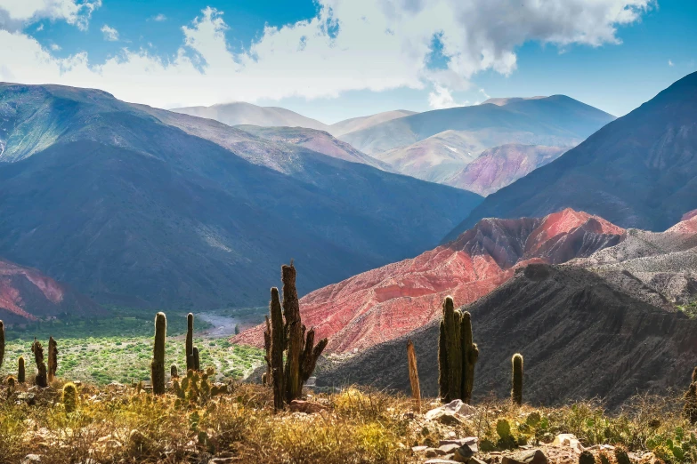 desert land is surrounded by mountains and blue sky