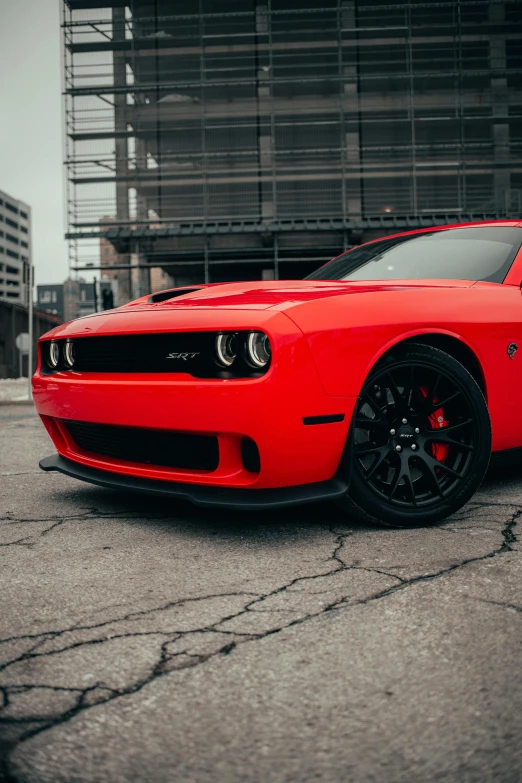 a red car is parked on the street with black tires