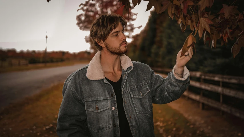 a man in grey jacket standing next to a street