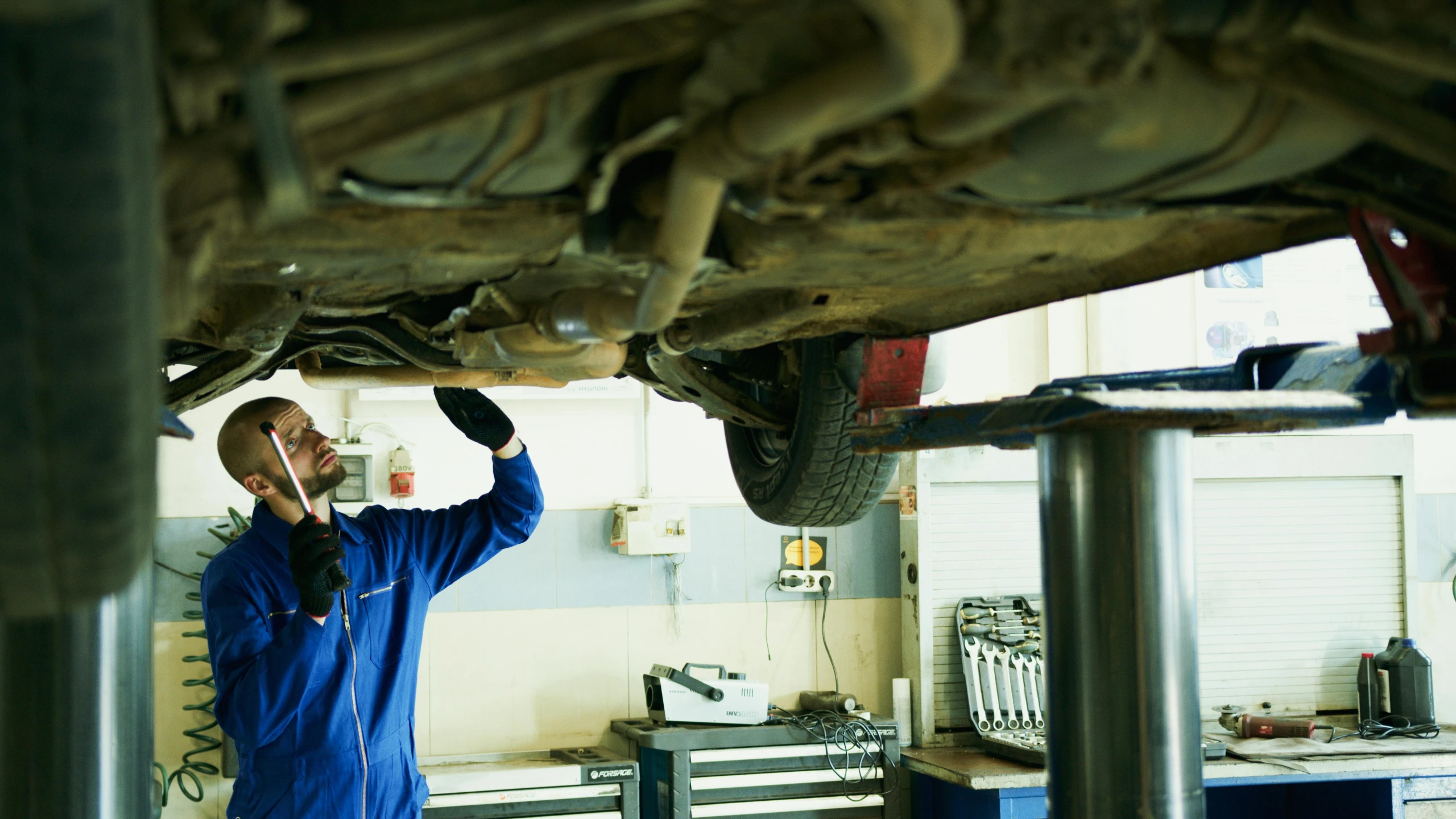 a mechanic working on a vehicle in a garage, by John Murdoch, shutterstock, 3 5 mm photo, 2995599206, blue print, romantic lead