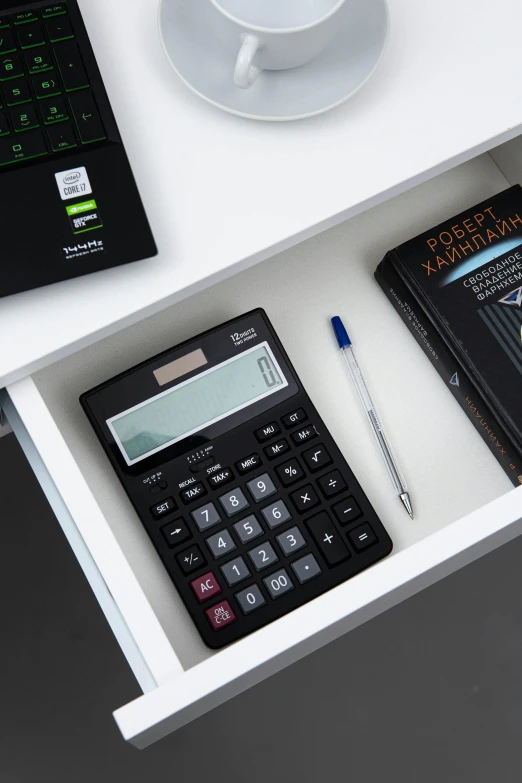 a laptop computer sitting on top of a desk next to a calculator, collection product, multiple stories, black, staples