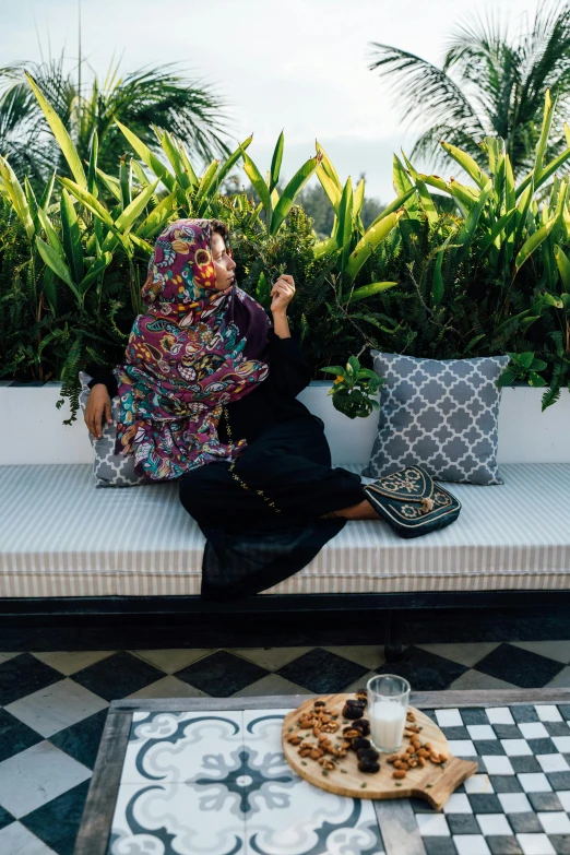 woman sitting on a bench eating cookies and drinking milk