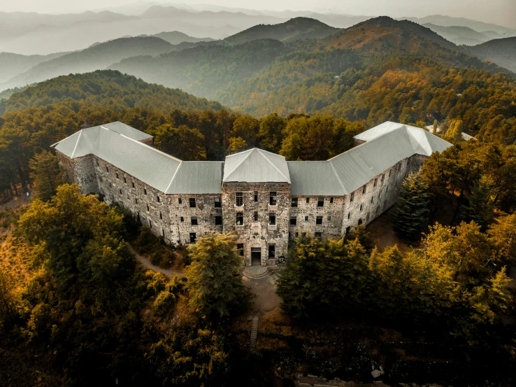 an aerial s of a castle sitting in the middle of a mountain range