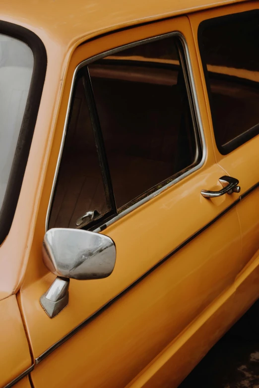 an orange car with the door open, showing it's reflection